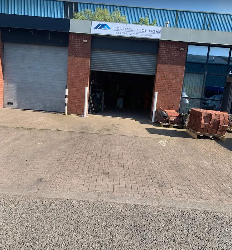A brick building with an open garage door and a sign reading 