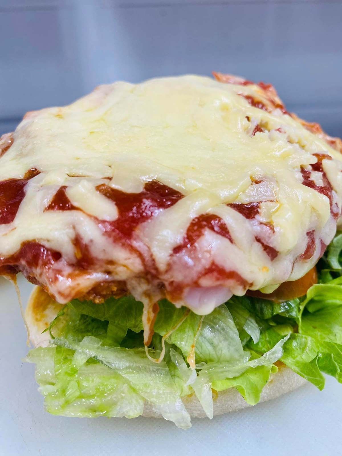 A Close Up of a Hamburger With Lettuce and Cheese — Cedar Park Fish & Chips In Taranganba, QLD