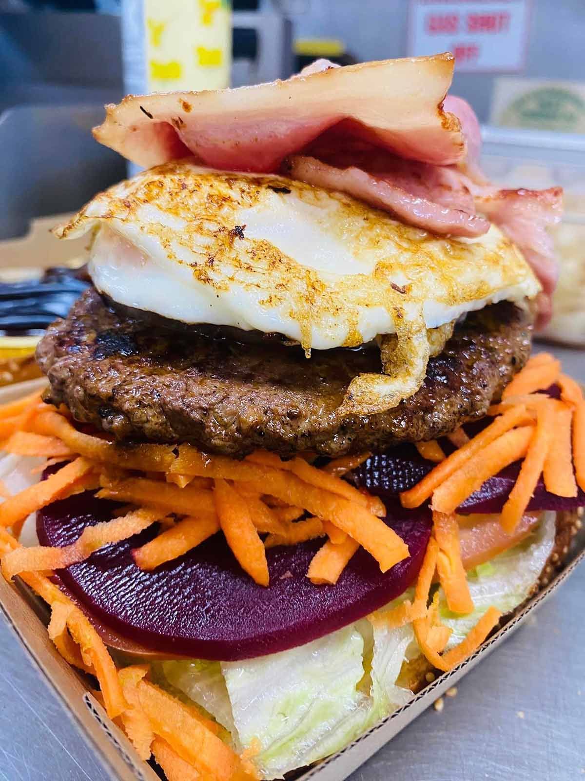 A Hamburger With Eggs, Carrots, Lettuce and Bacon — Cedar Park Fish & Chips In Taranganba, QLD