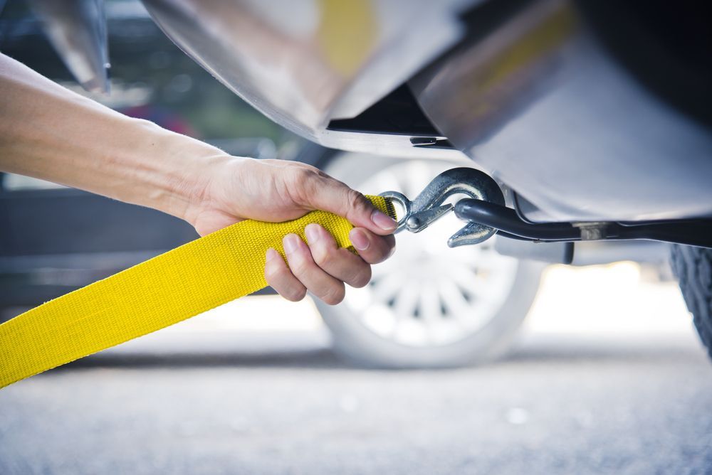 Hand Holding Yellow Car Towing Strap