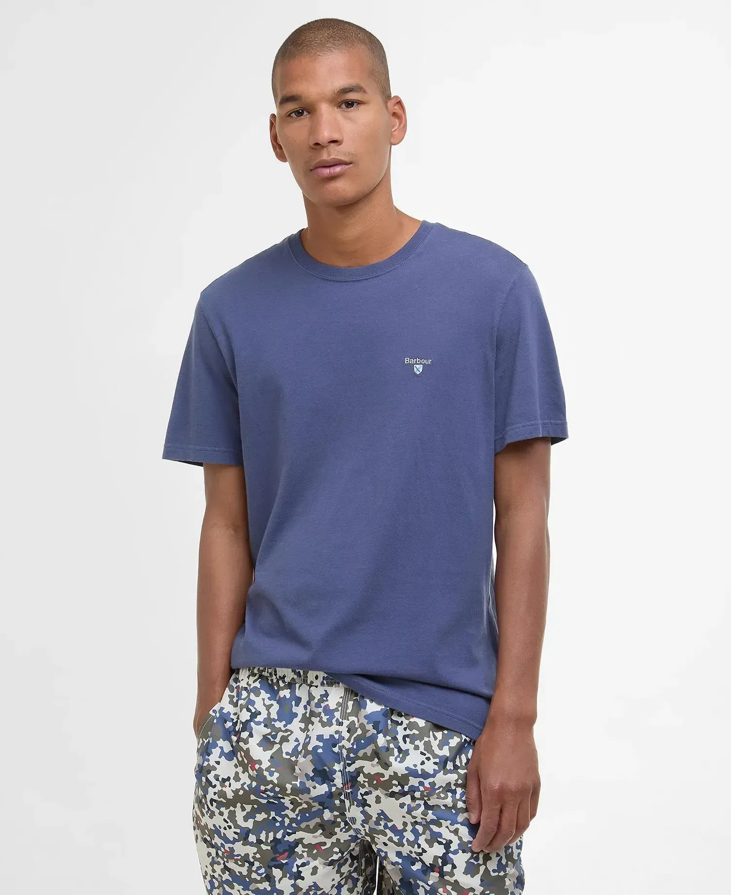 Un uomo che indossa una maglietta blu e pantaloncini mimetici