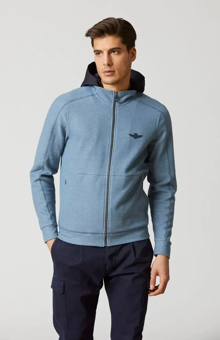 Un uomo che indossa una giacca azzurra con cappuccio