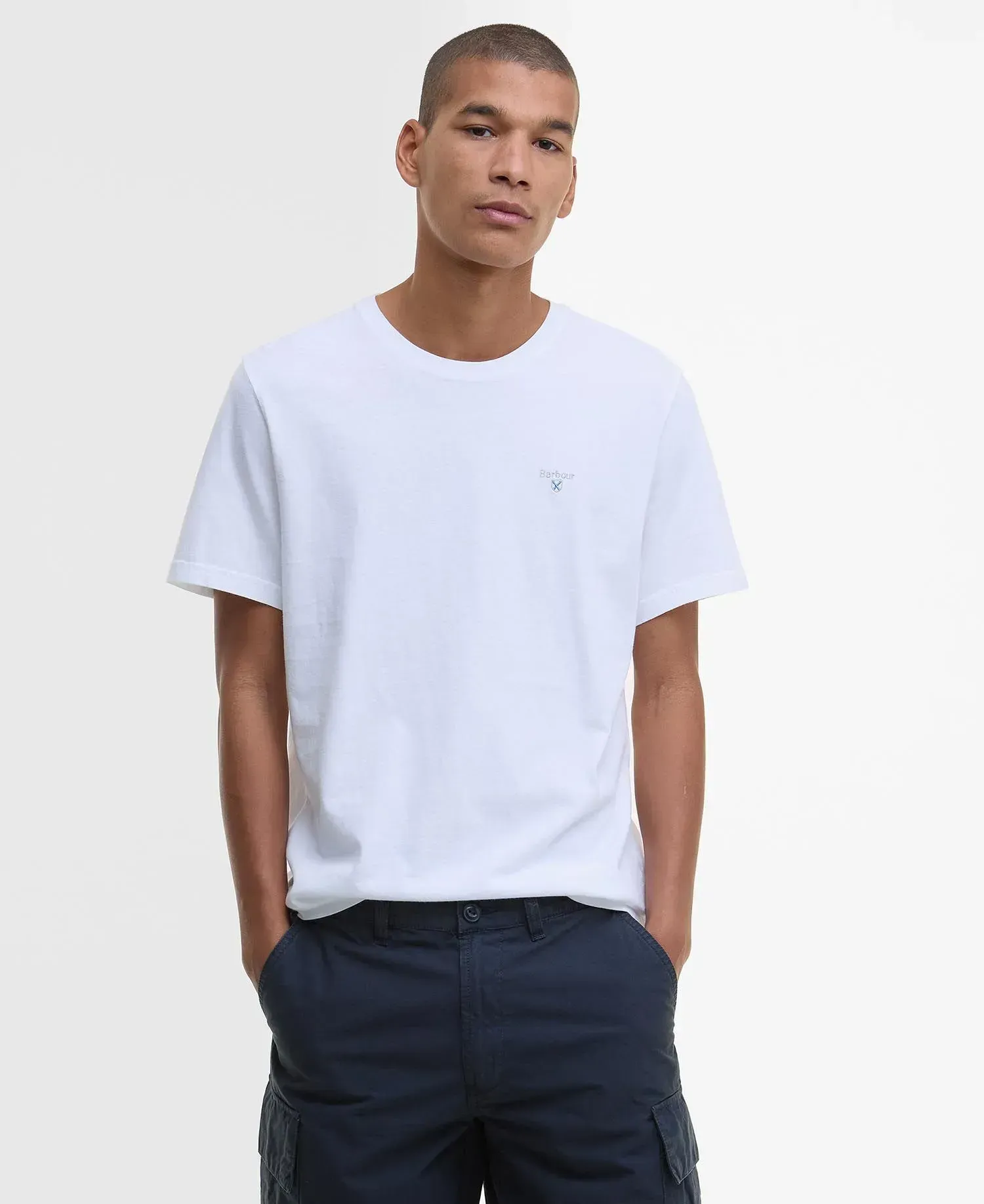 Un uomo indossa una maglietta bianca e pantaloncini blu.