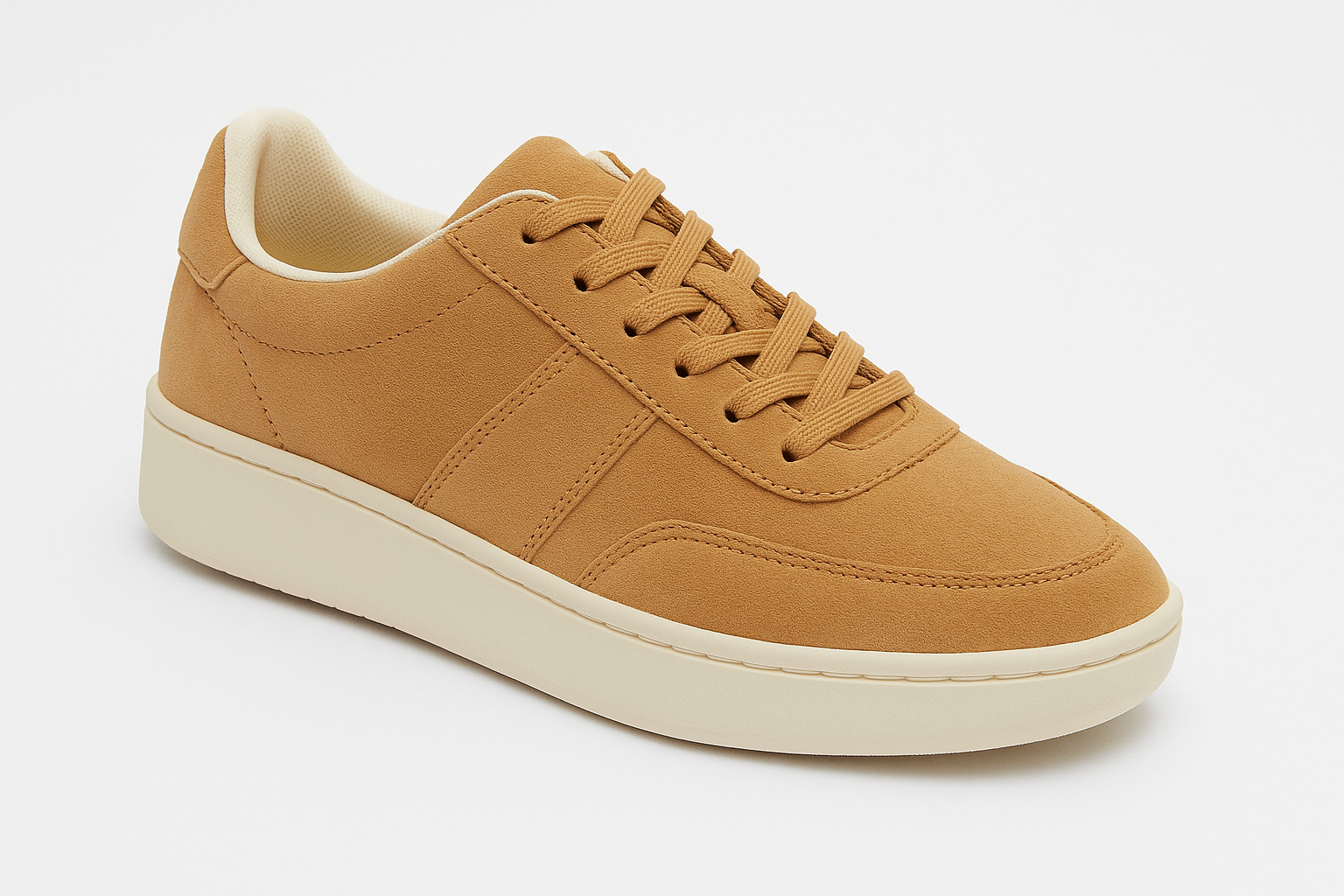 Un paio di scarpe da ginnastica marroni con suola bianca su sfondo bianco.