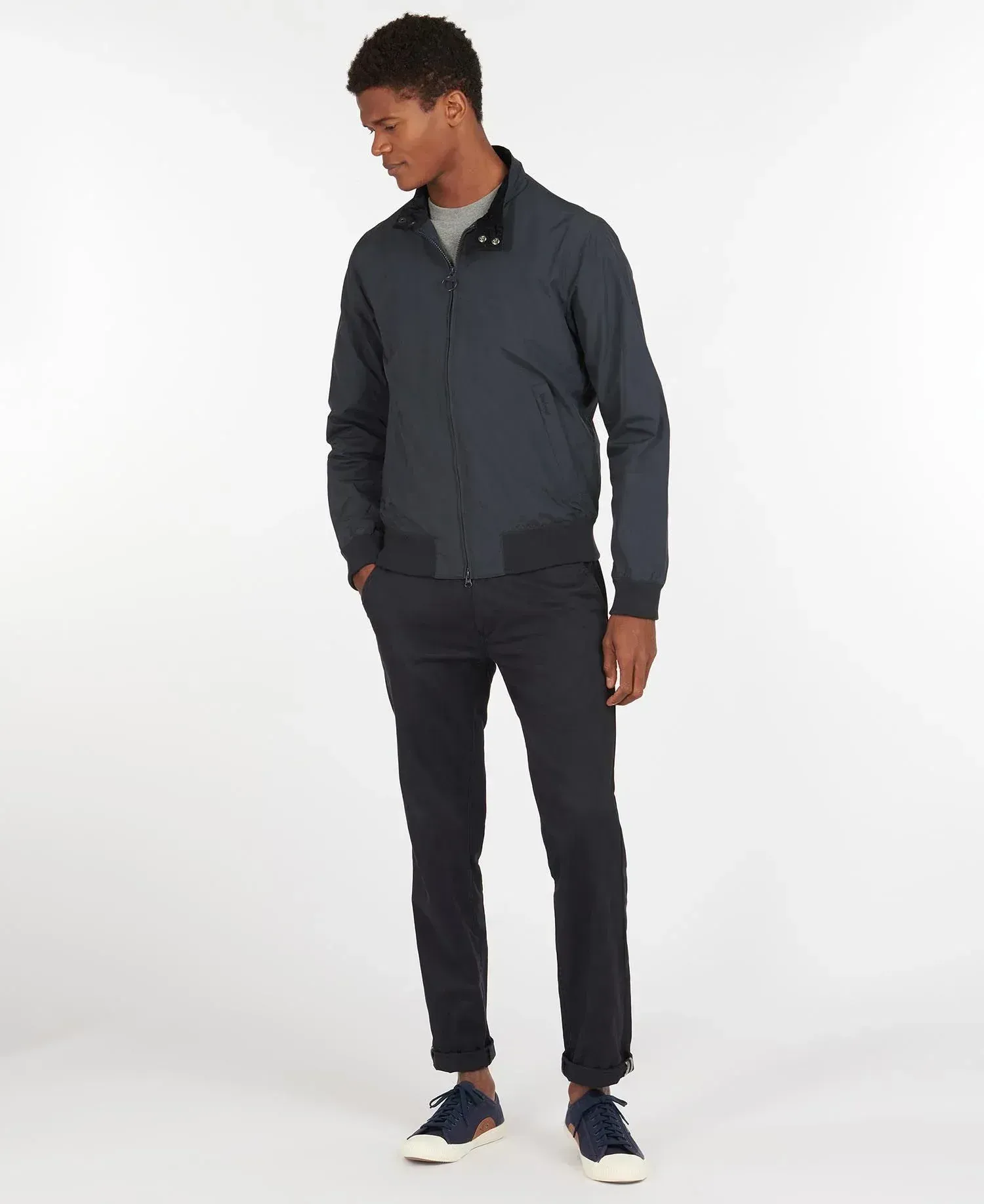 Un uomo indossa una giacca blu e pantaloni neri.