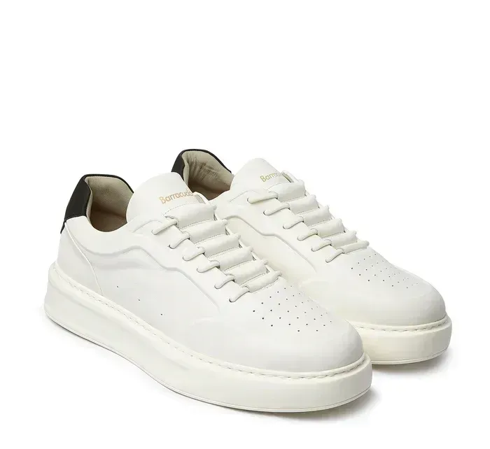 Un paio di scarpe da ginnastica bianche con suola nera su sfondo bianco.