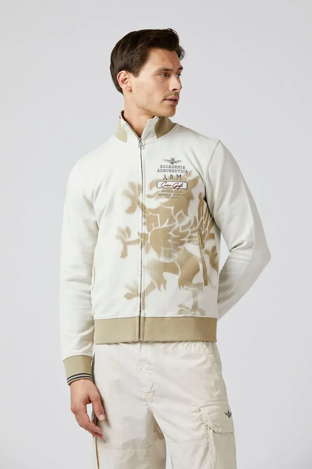 Un uomo che indossa una giacca bianca con un leone sopra