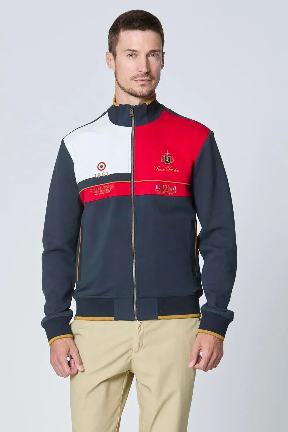 Un uomo indossa una giacca blu con strisce rosse, bianche e blu