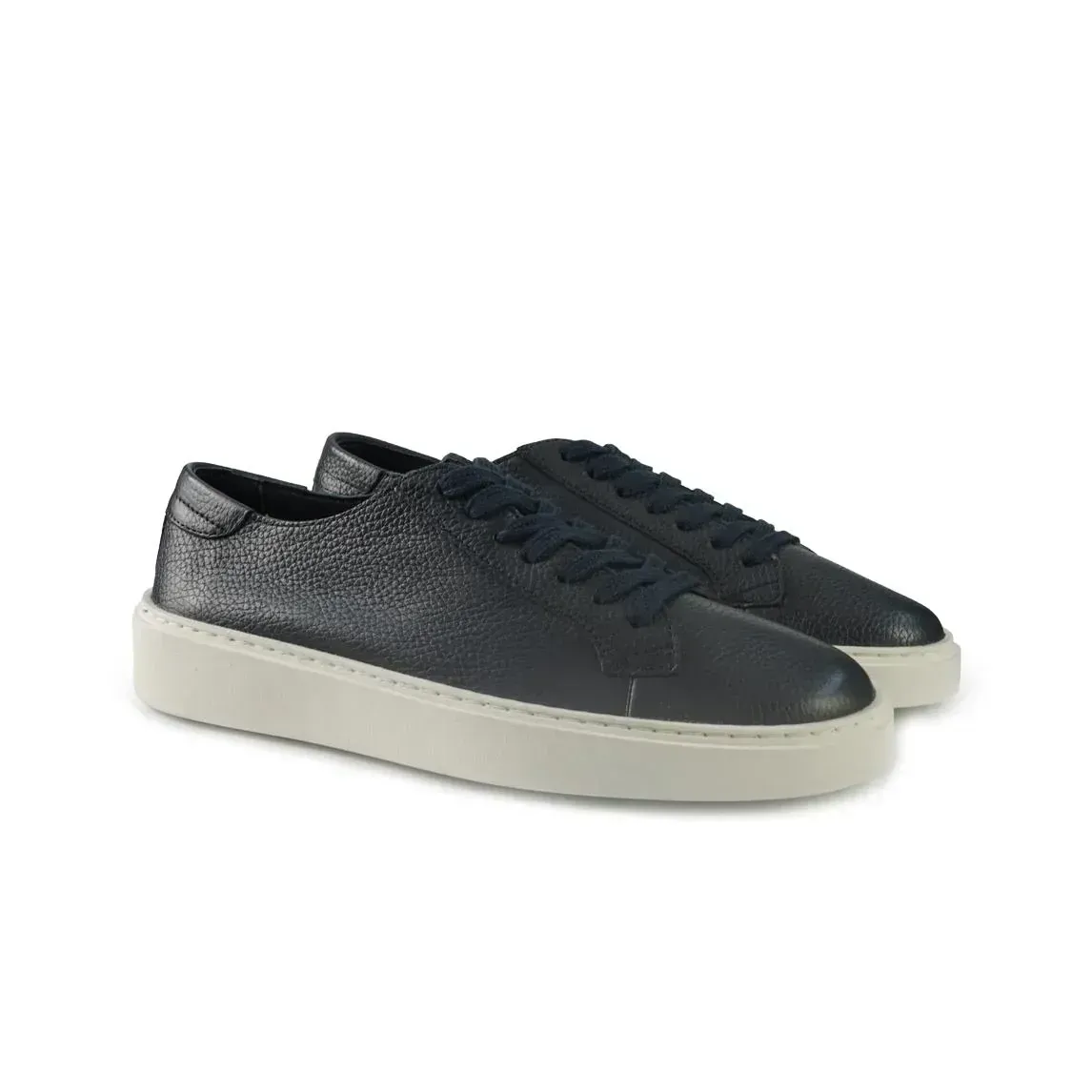 Un paio di scarpe da ginnastica nere con suola bianca su sfondo bianco.