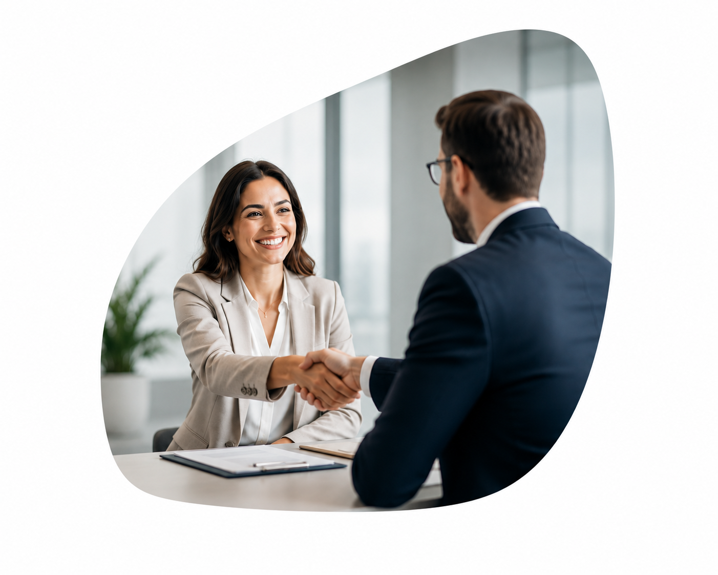 Two people are shaking hands in front of a tablet.