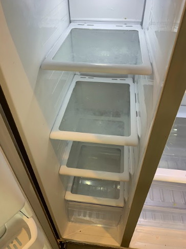 Tall narrow white cabinet with glass shelves and a metal bar inside, viewed through an open door.