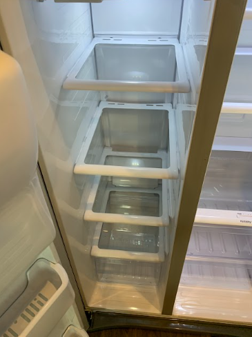 Open refrigerator freezer drawers with clear bins and white shelves.