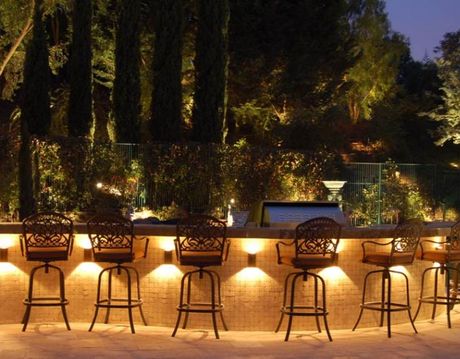 A row of bar stools are lit up at night