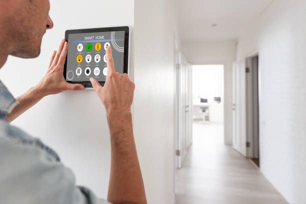 A man is using a tablet to control a smart home.