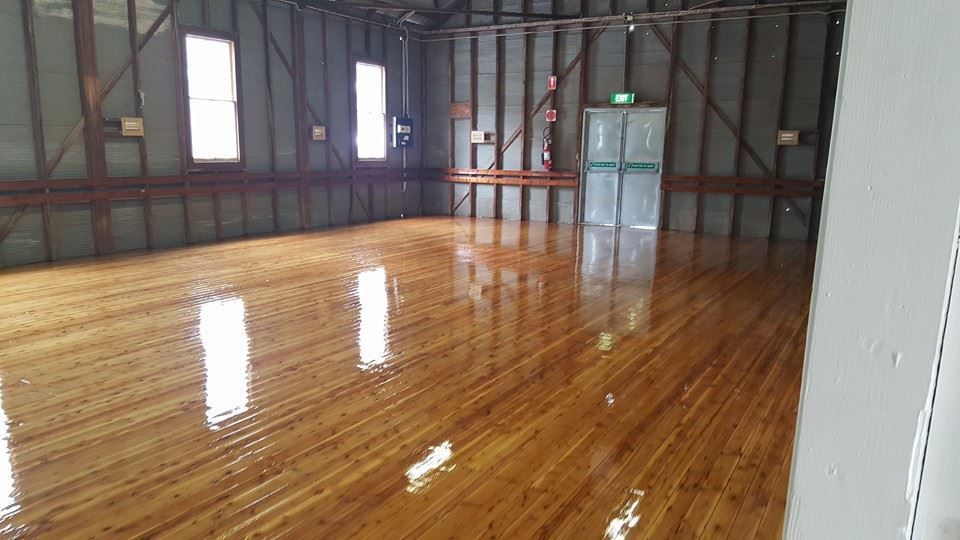 An empty room with hardwood floors and white walls.