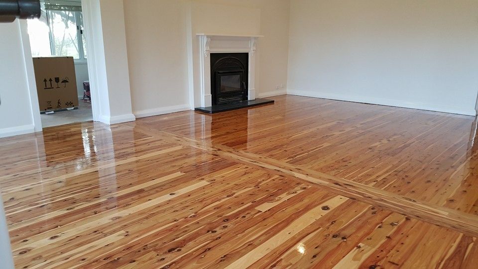 A living room with a wooden floor and a fireplace.