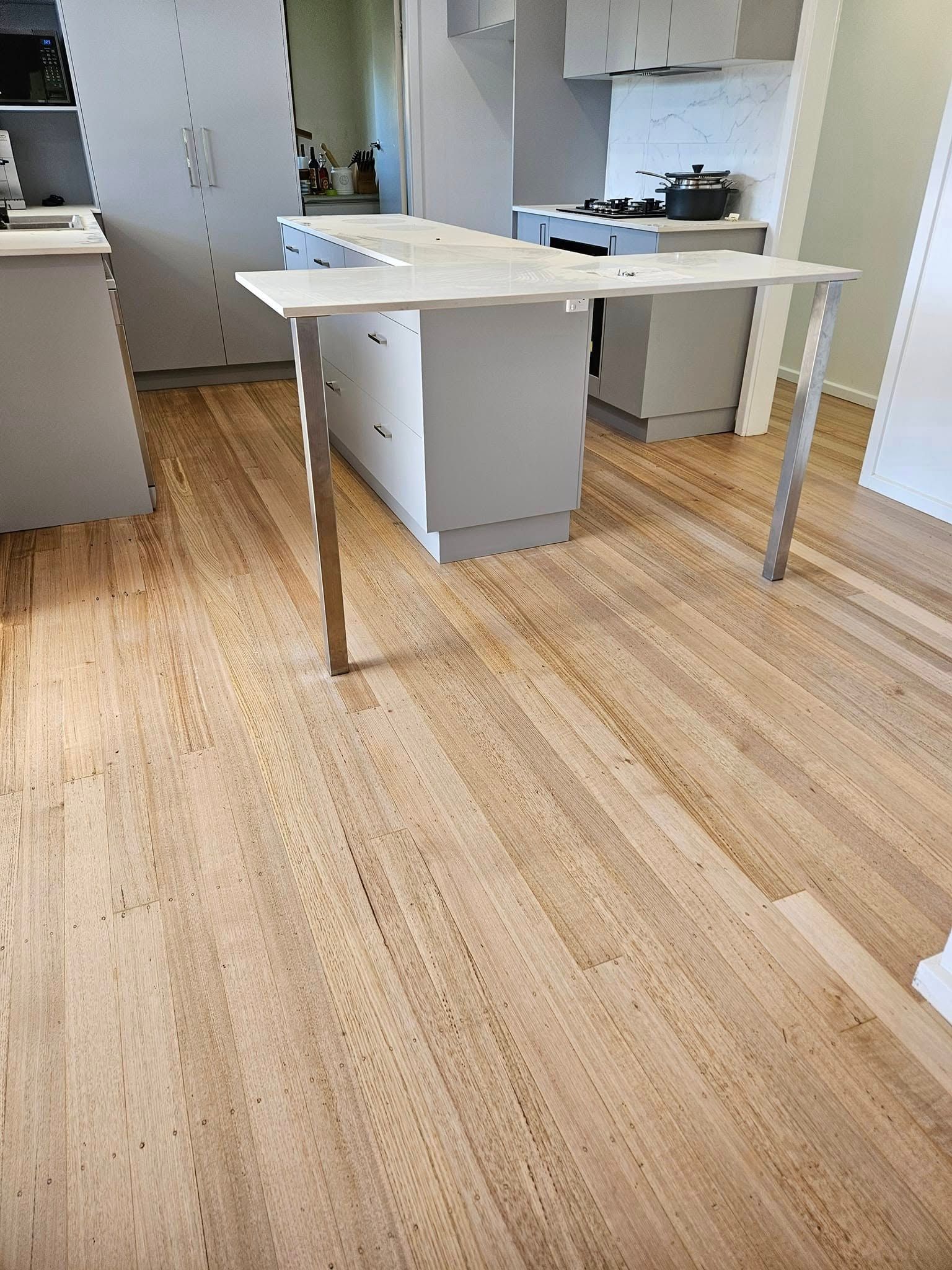 A kitchen with a wooden floor and a table.