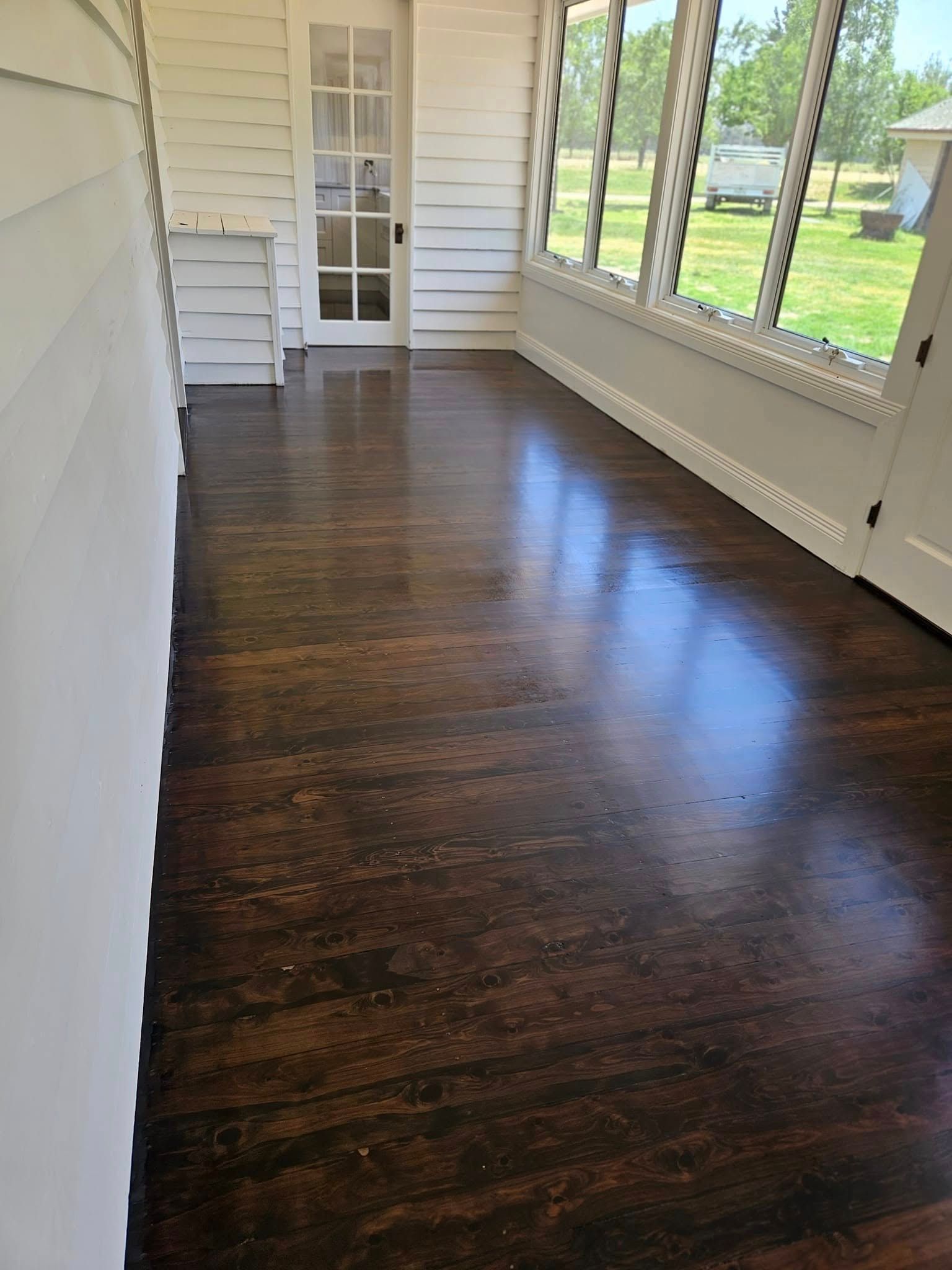 A room with a wooden floor and a lot of windows.