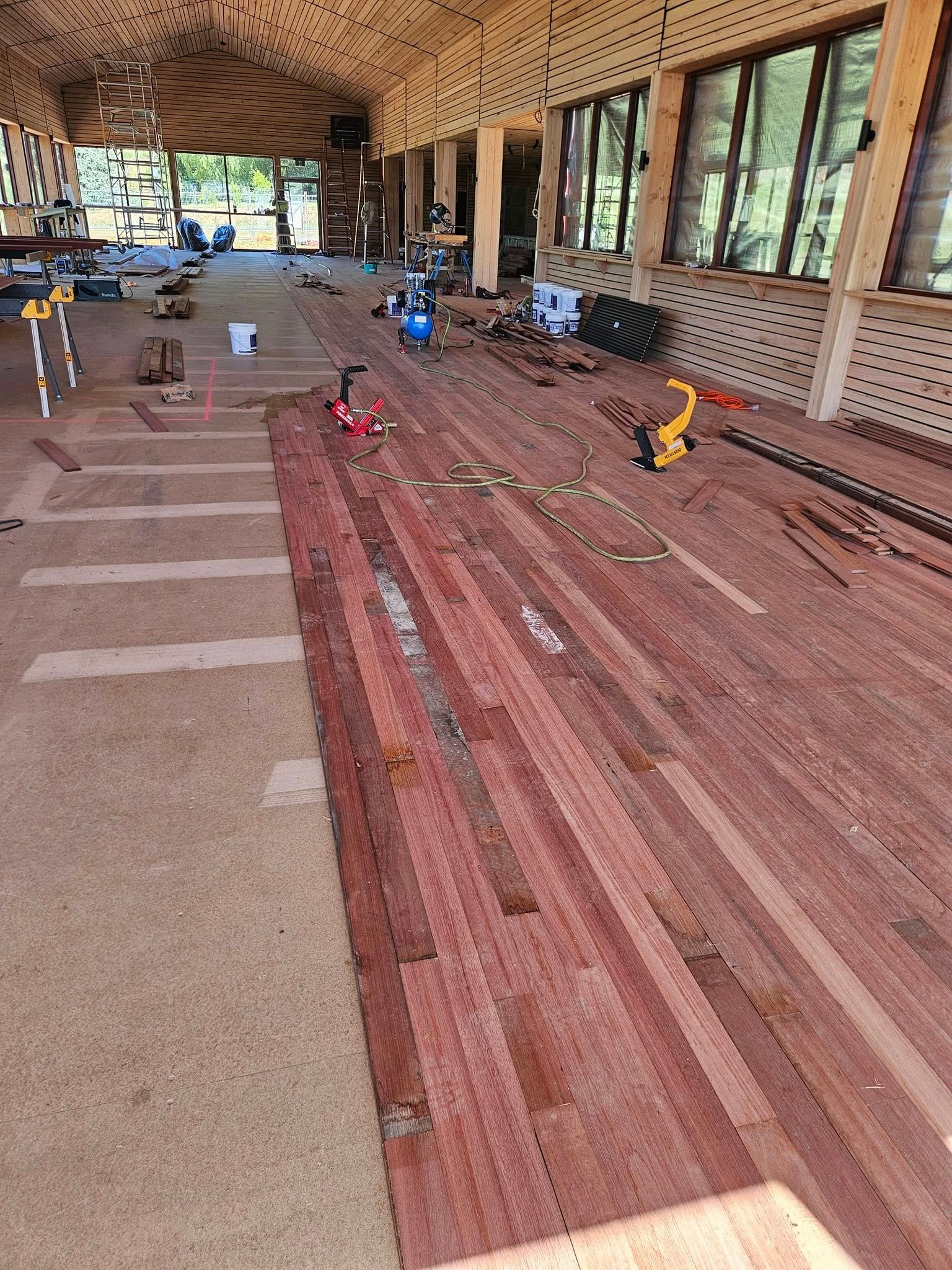 A large wooden floor is being built in a building.