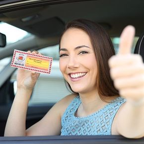 a woman holding a driving school gift voucher