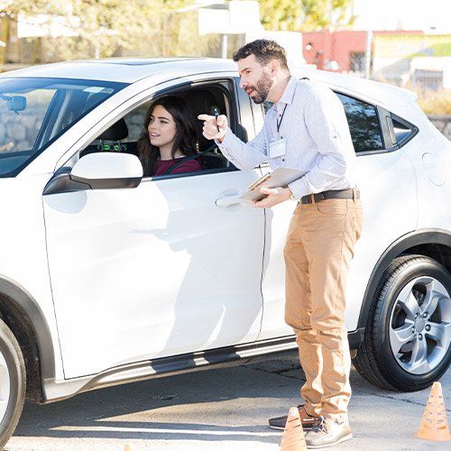 a man giving driving instructions to a woman