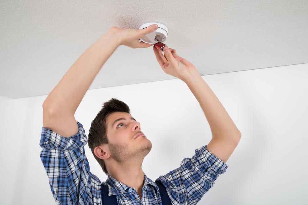 Electrician Repairing Smoke Detector — GSA Group In Garbutt, QLD