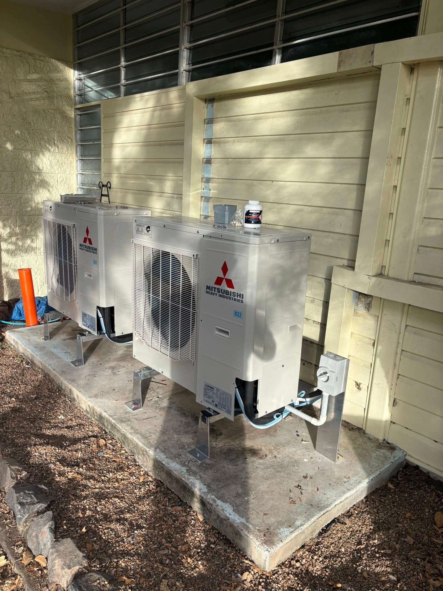 Person Removing Air Filters From A White Air Conditioner On A White Wall — GSA Group In Garbutt, QLD