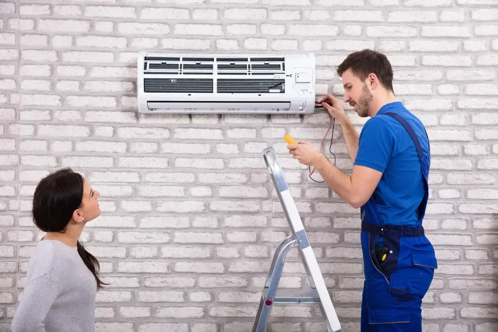 Male Worker Speaking with Female Client About Air Conditioner — GSA Group In Garbutt, QLD