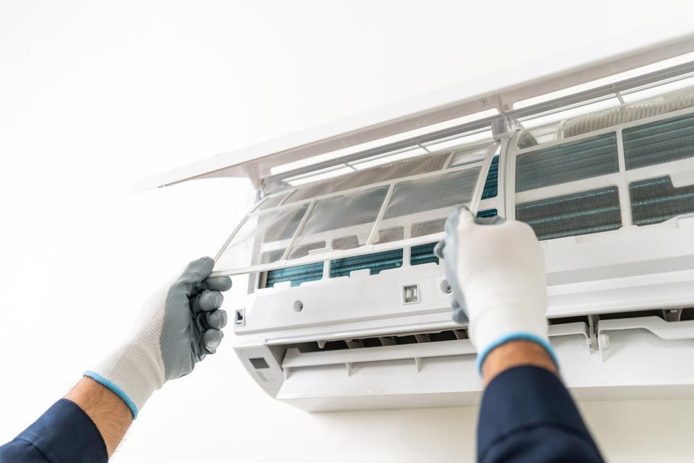 Man Placing An Air Conditioning Unit Filter