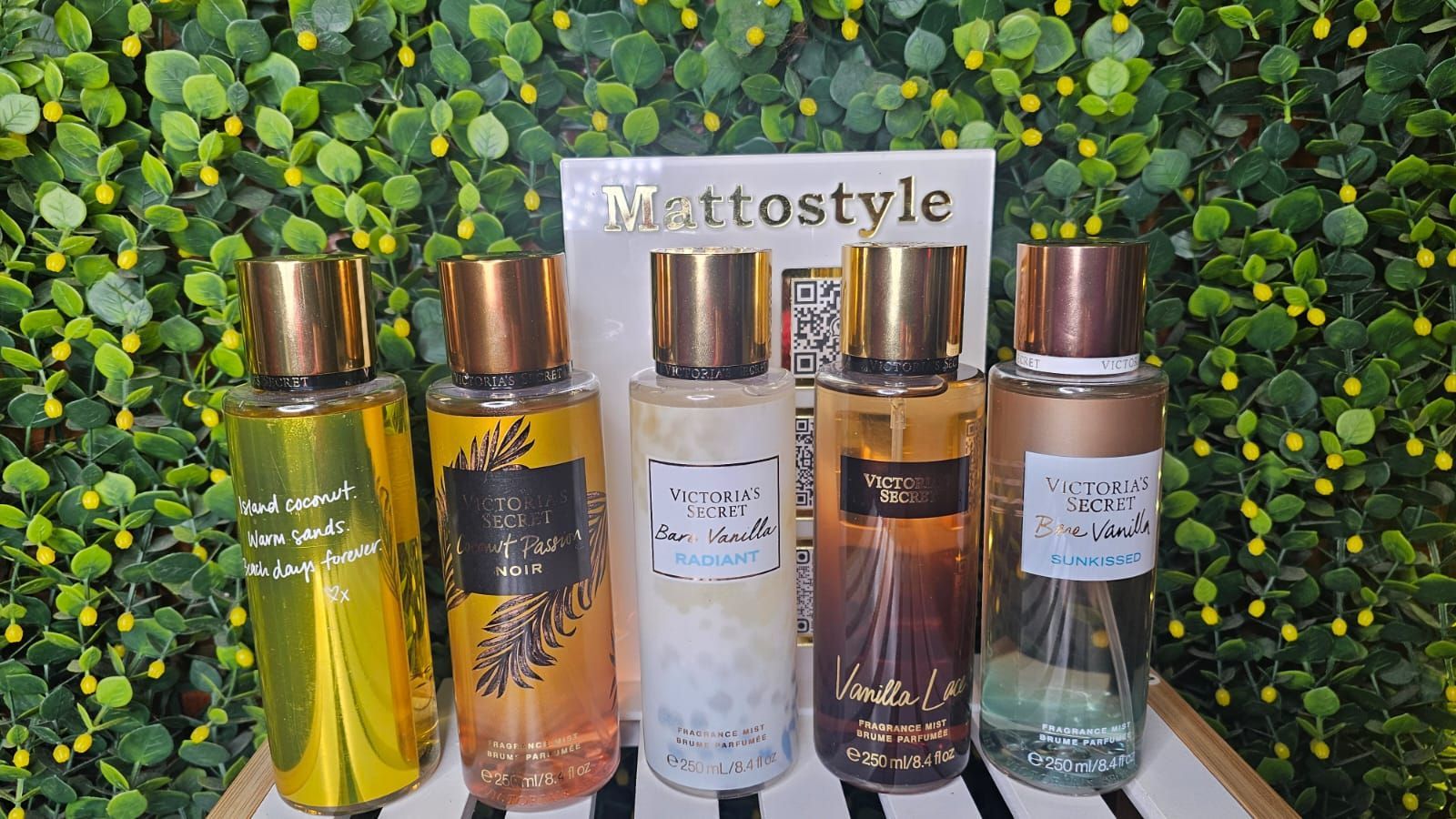 Fila de varias brumas de fragancias de Victoria's Secret con tapas doradas alineadas sobre una superficie.