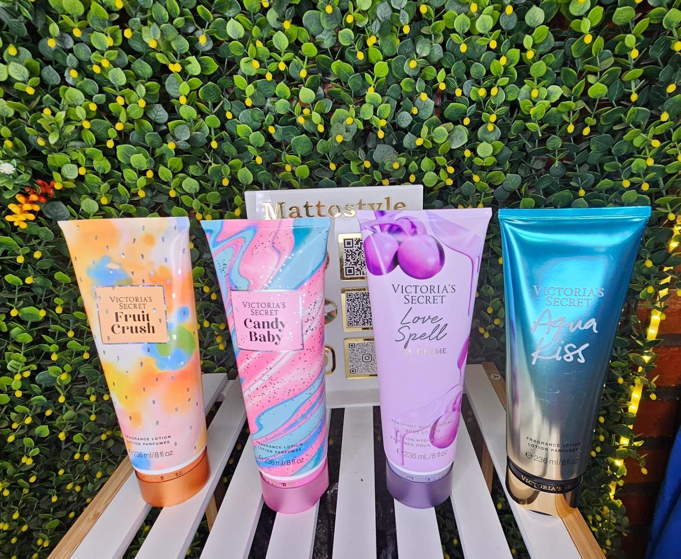 Cuatro tubos de loción Victoria's Secret: dorado, negro floral, rosa con purpurina y morado