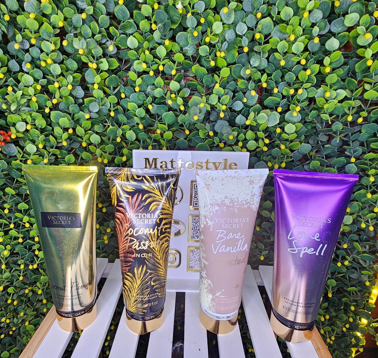 Cuatro tubos de loción Victoria's Secret: dorado, negro floral, rosa con purpurina y morado