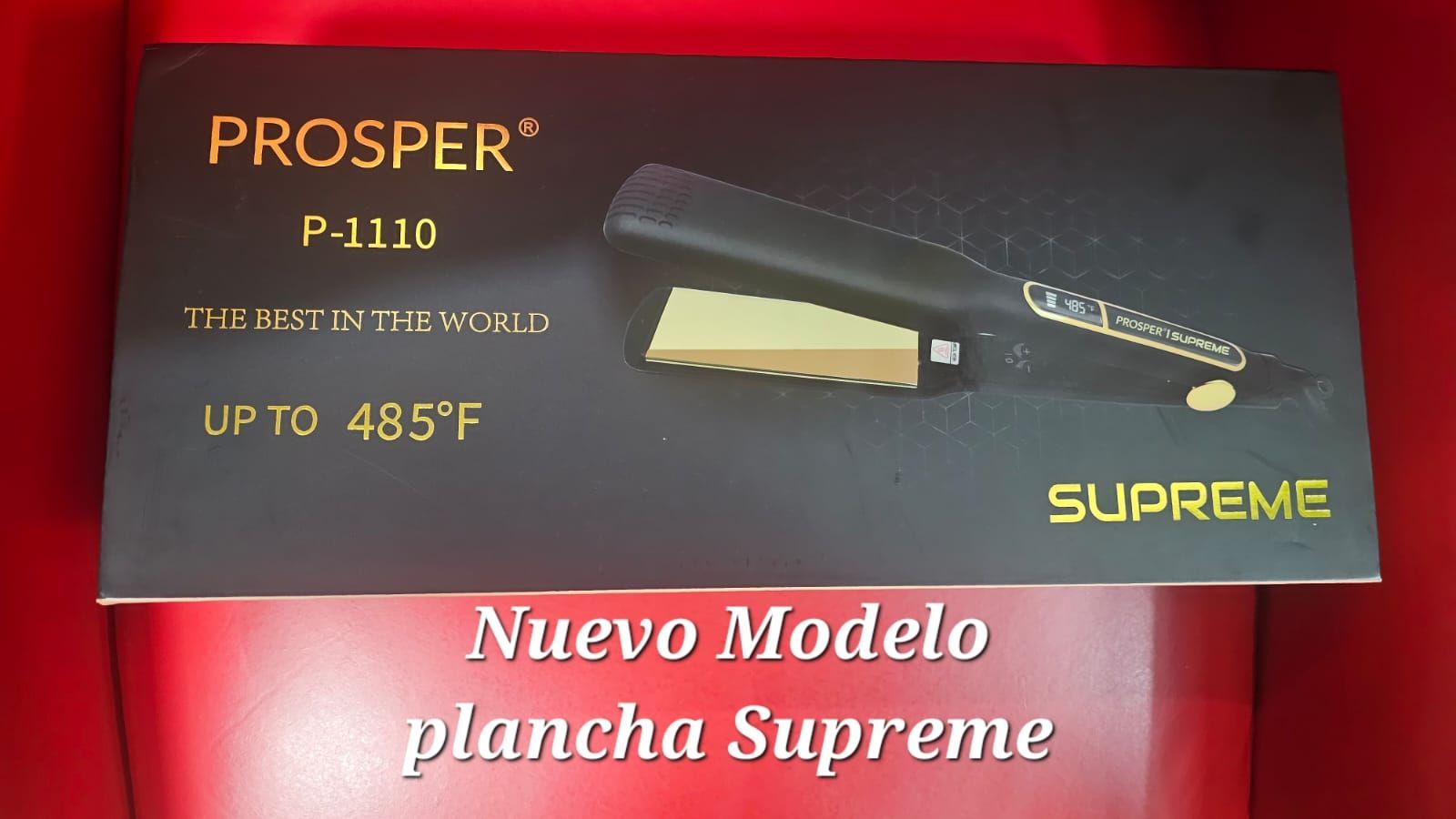 Plancha de pelo negra y dorada con caja, sobre fondo blanco.