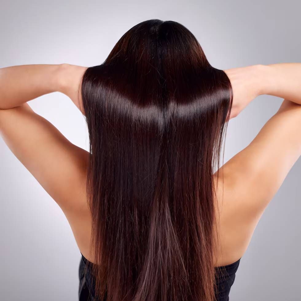 La espalda de una mujer con cabello largo y castaño.