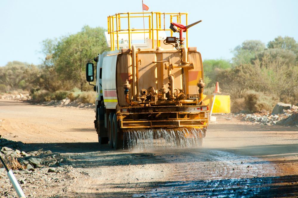 Water Truck Spraying Dust-control Water on a Dirt Road in an Arid — Mareeba Crane Hire In Mareeba, QLD