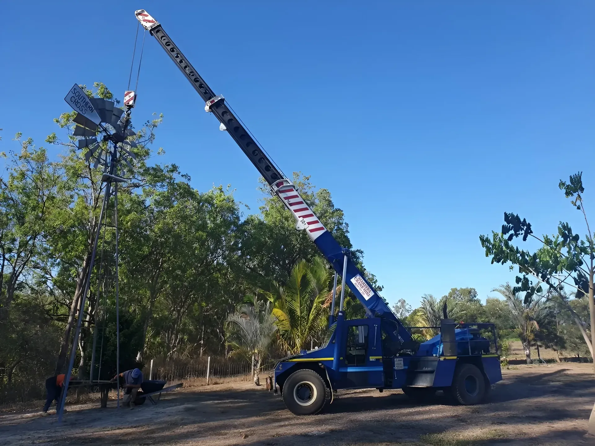 Yellow Construction Crane Lifting Materials at a Construction Site — Mareeba Crane Hire In Mareeba, QLD