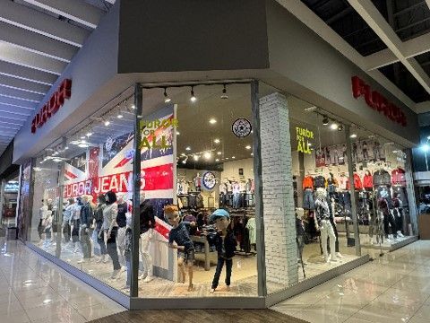 Un frente de tienda con muchos maniquíes frente a él. Furor Jeans