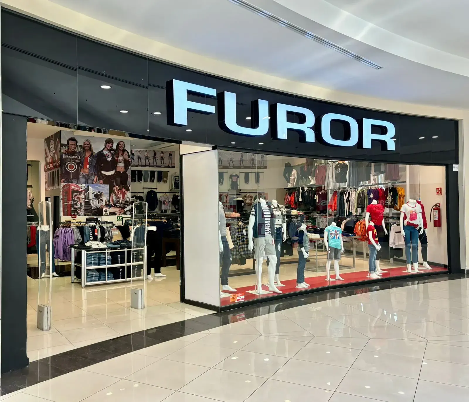 Una tienda de furor en un centro comercial con maniquíes frente a ella. Furor Jeans