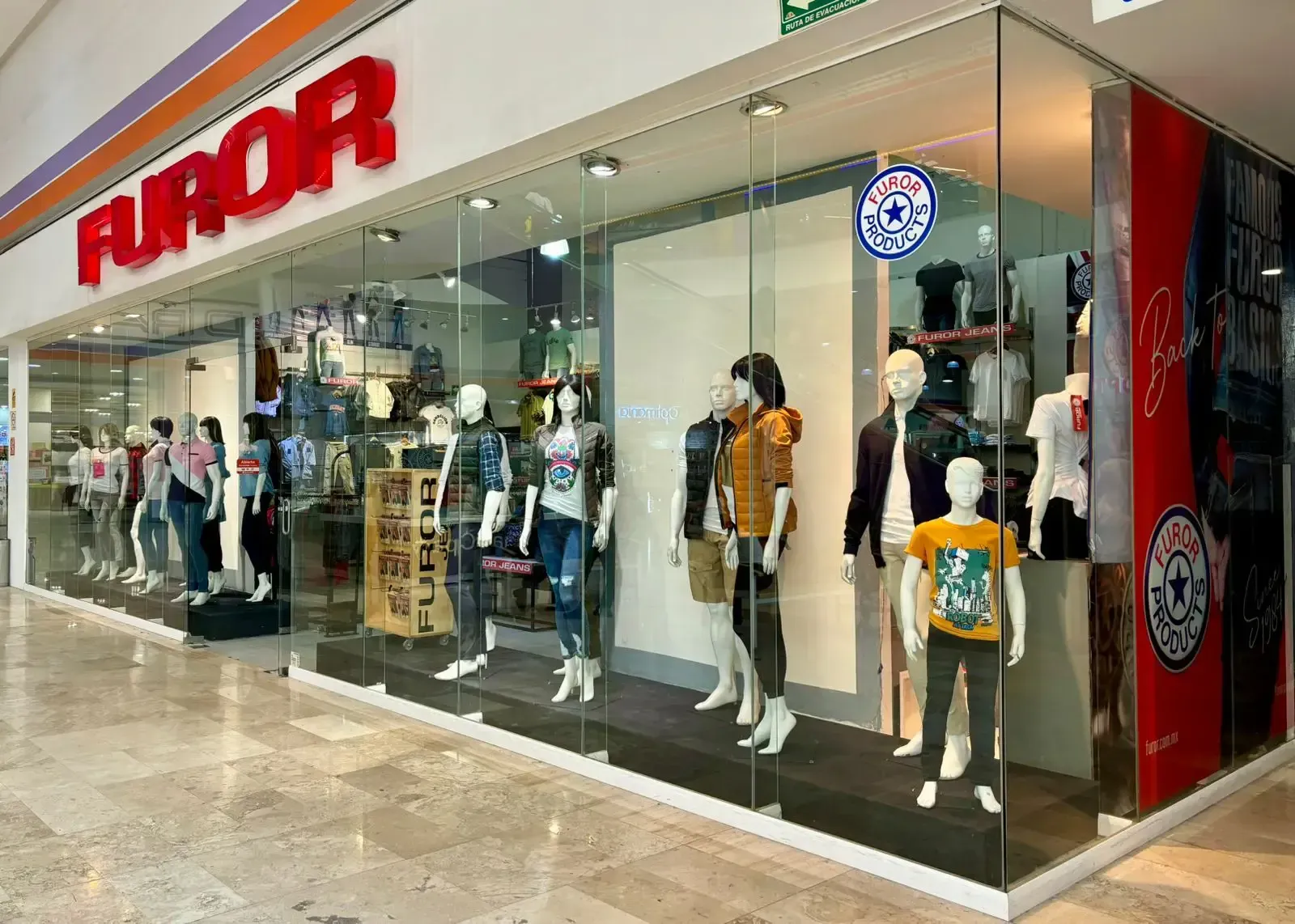 El frente de una tienda con muchos maniquíes frente a ella. Furor Jeans