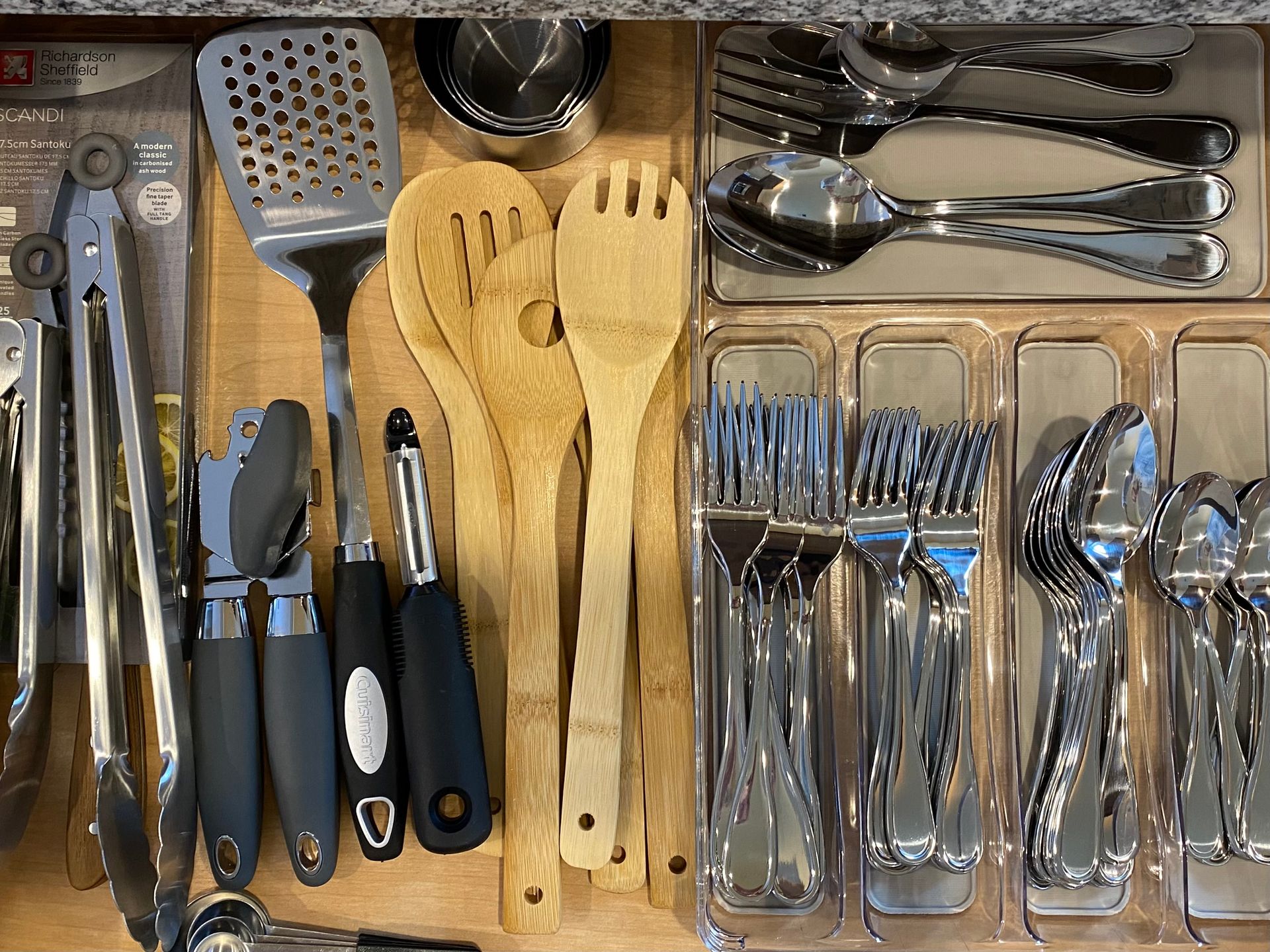 Kitchen drawer with utensils: tongs, spatulas, wooden spoons, forks, knives, and spoons. By Robin Bradley Designs 
