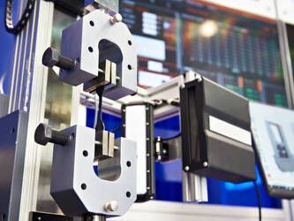 Picture of a flexure testing machine testing a resin sample