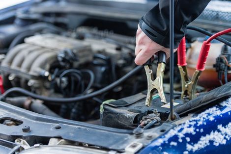 Person Fixing Vehicle Battery — Cedar Falls, IA — Rasmusson Towing