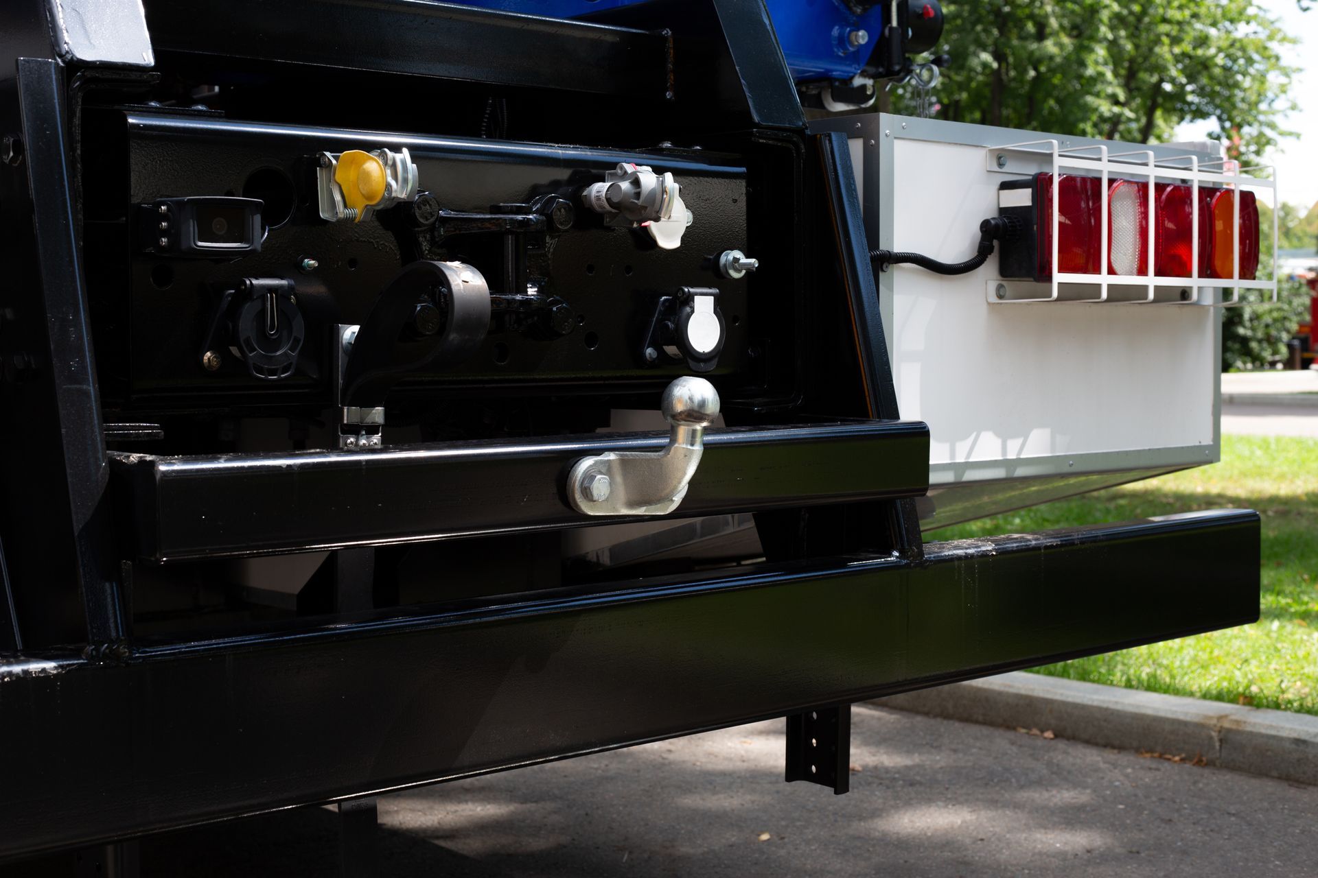Rear view of a truck with tow hitch and connectors in a parking area. Rear view of a truck with tow hitch and connectors in a parking area.