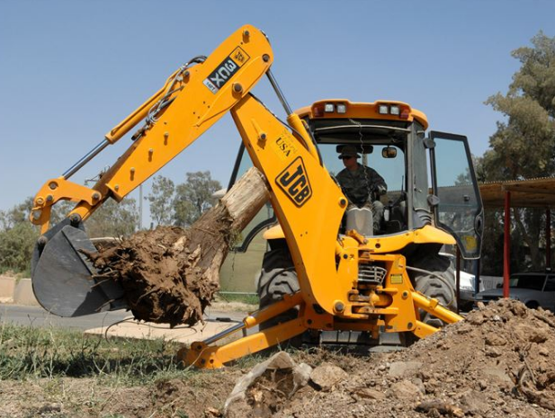 Excavator removing stump from earth