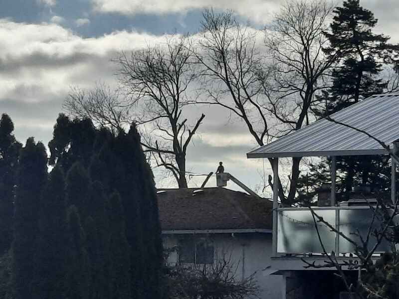 Tree service worker in a distant boom truck bucket 3