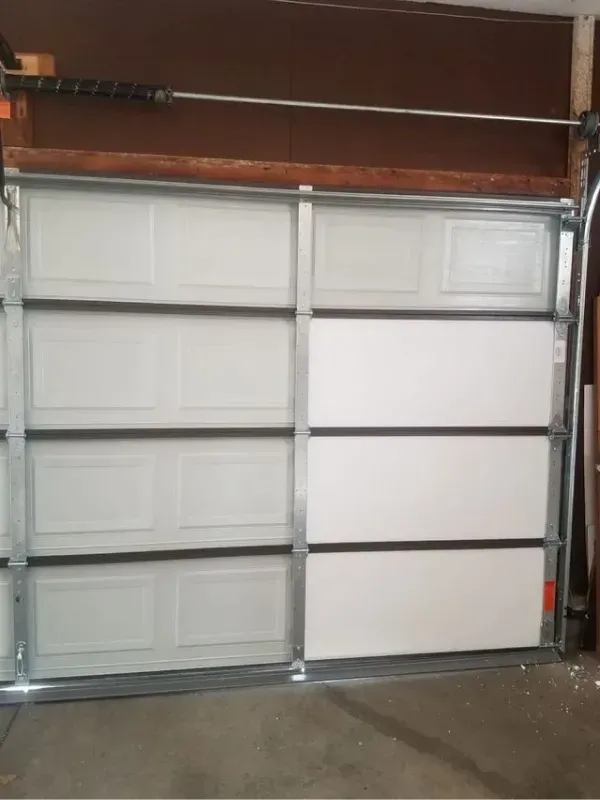 White garage door with eight rectangular panels, closed. Steel frame, brown trim.