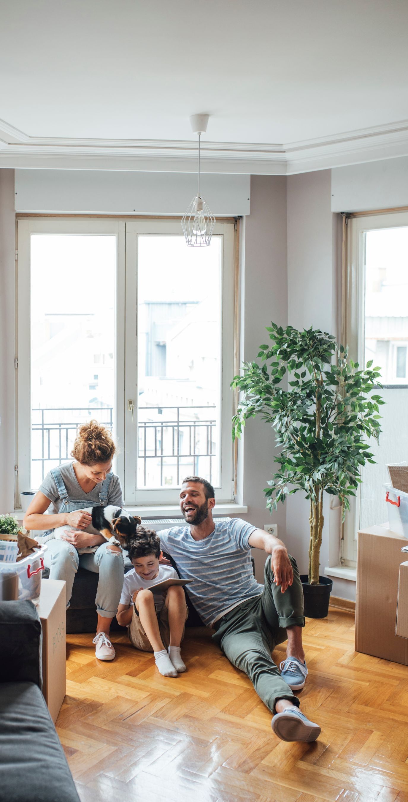 A family is sitting on the floor in a living room.
