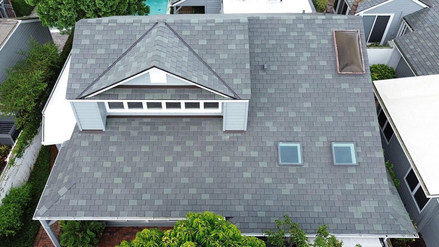 An aerial view of a house with a gray roof and two skylights.