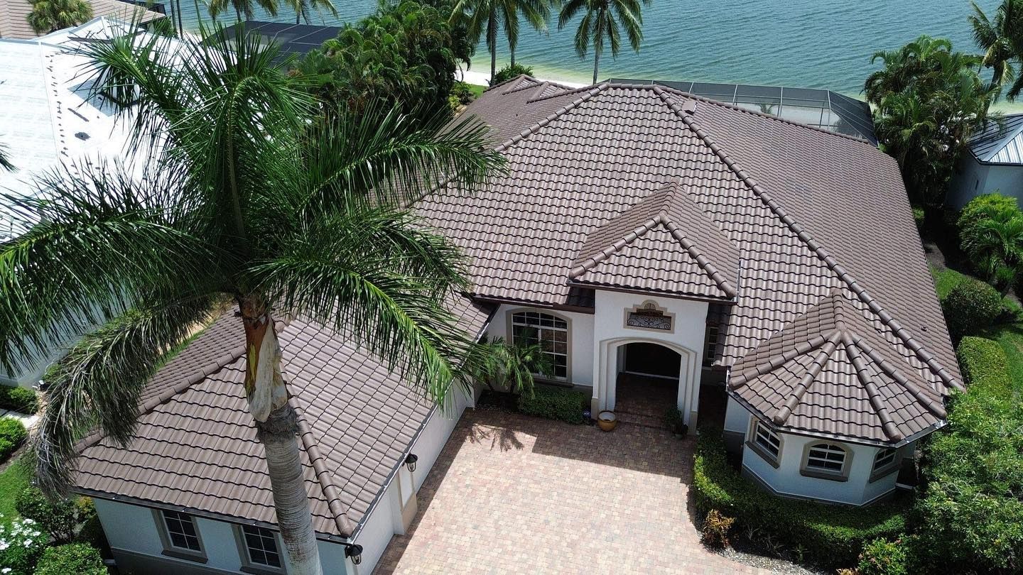 An aerial view of a large house with a palm tree in front of it.