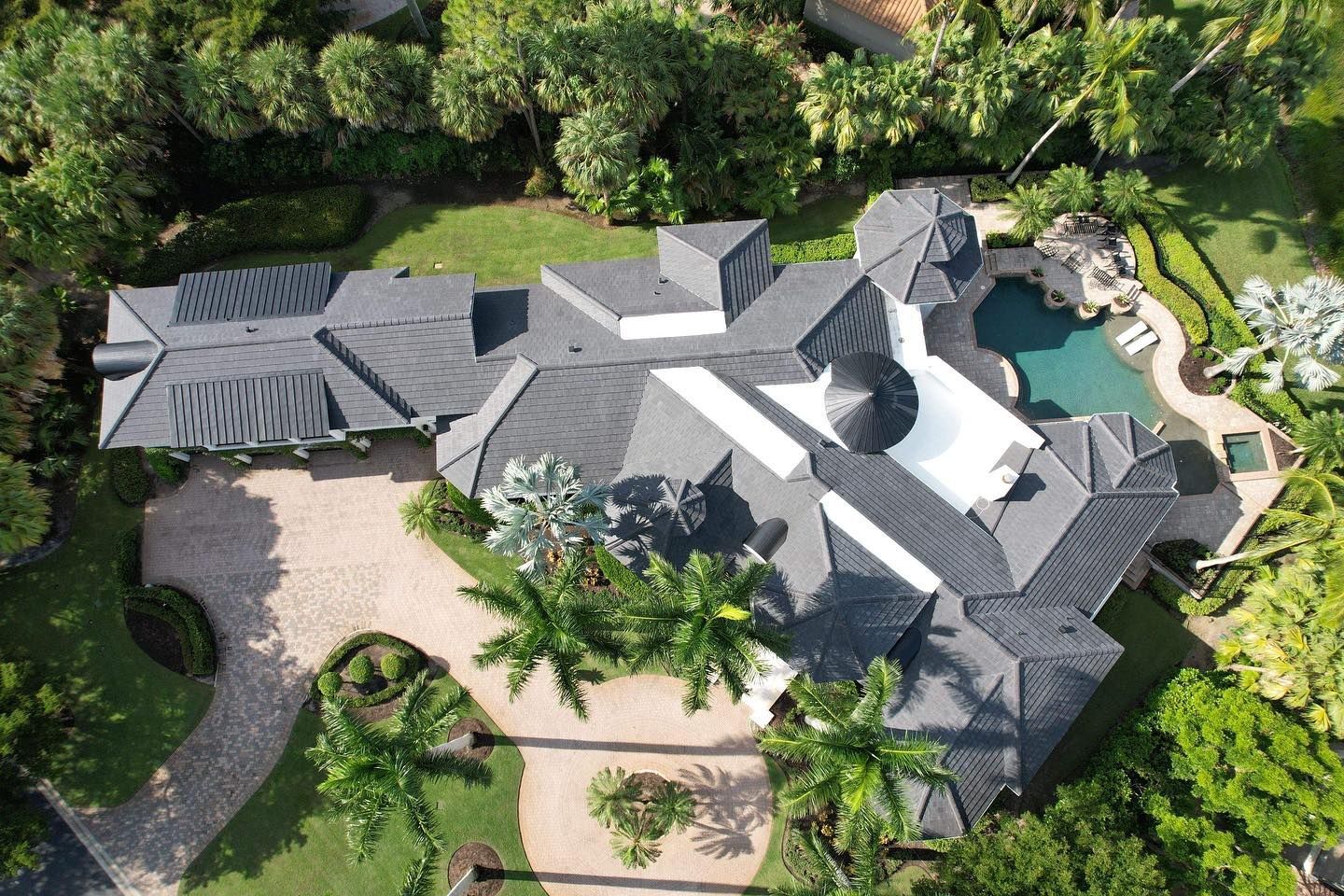 An aerial view of a large house with a pool